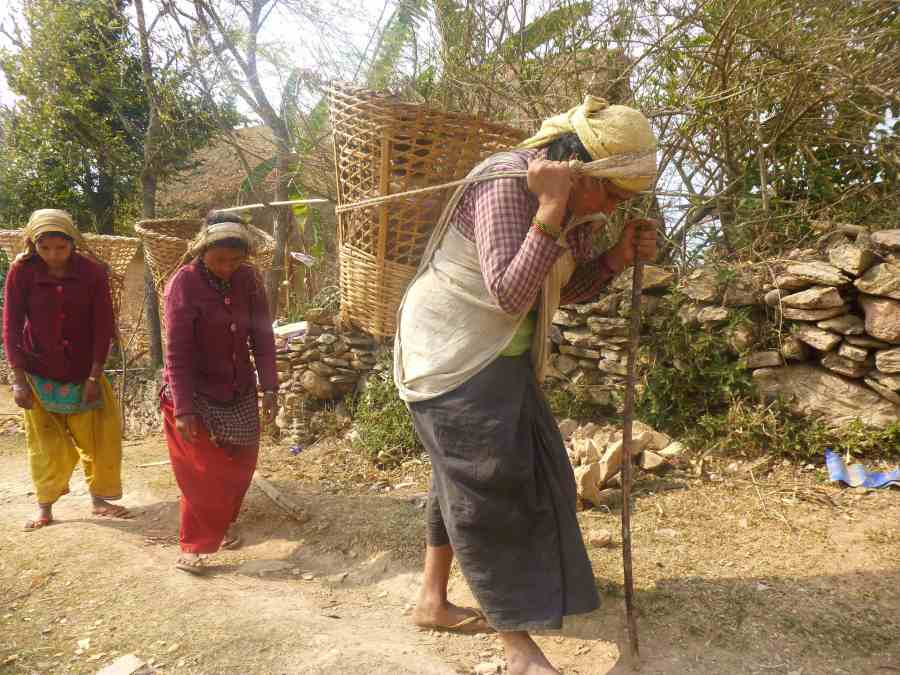 Women carrying heavy loads back to their village