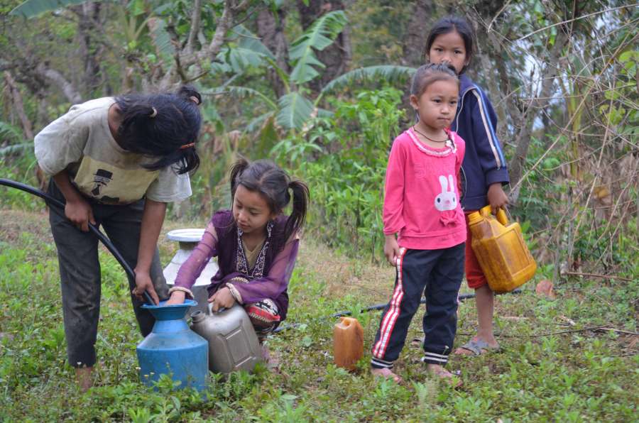 Children collecting water and bringing it back to the village