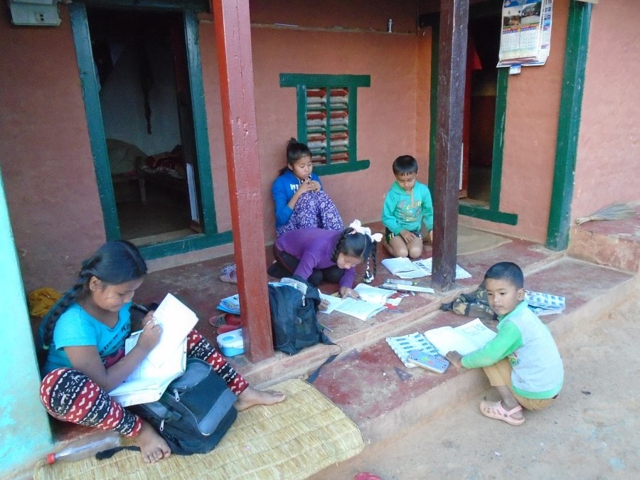 Nuna’s daughters, nephew and their friends finishing schoolwork outside their home