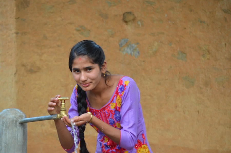 Sushmita using the new tap in her village in Nepal. 