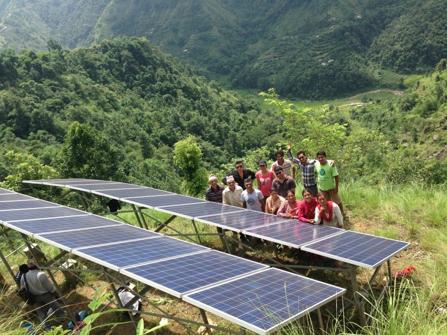 Tripti (in pink) with other Renewable World regional staff and community members at the Sirubari SolarMUS system