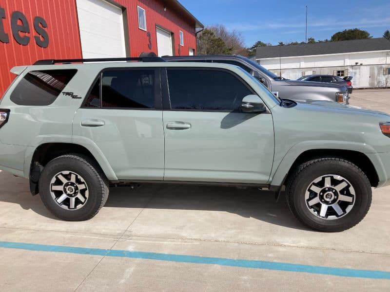 Light green SUV parked outside Inside Out Auto dealership.