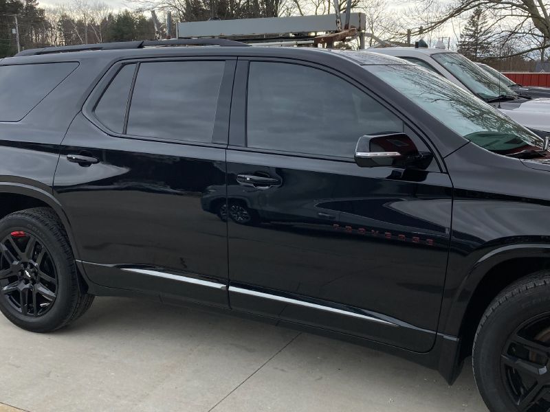 Black SUV parked outdoors at Inside Out Auto dealership.
