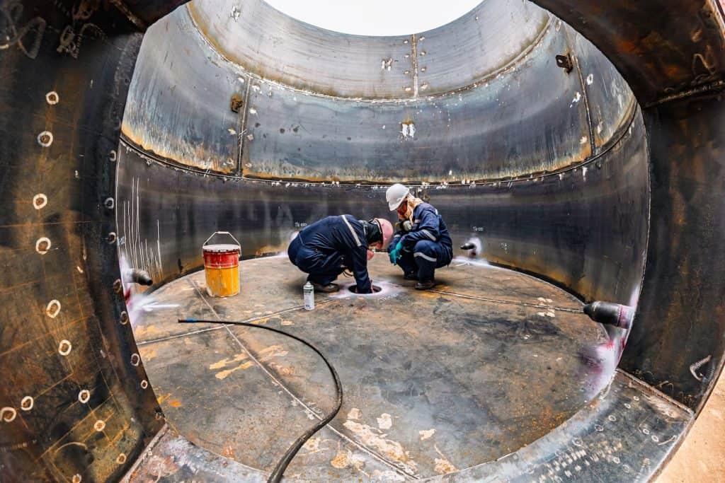 Industrial inspection inside large metal tank for safety and integrity.