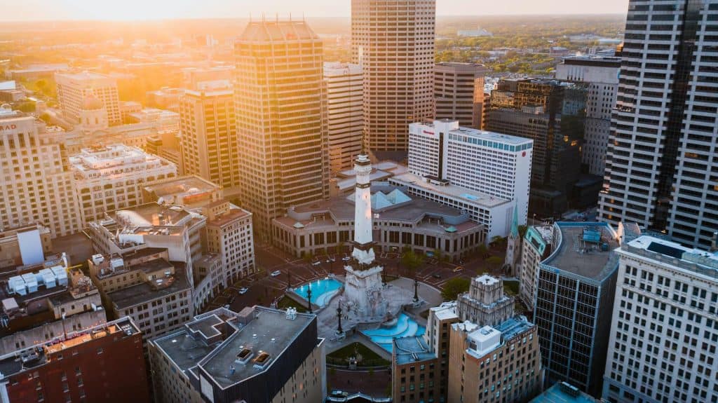 Aerial view of downtown with skyscrapers and a central monument at sunset.