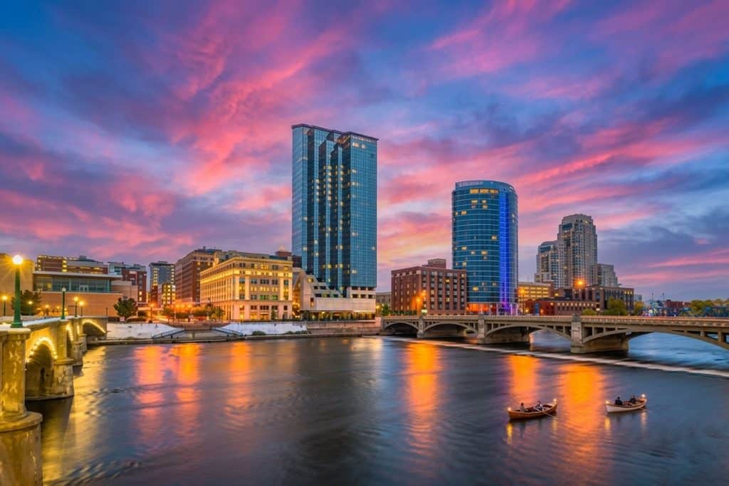 City skyline with modern buildings and river view at sunset.
