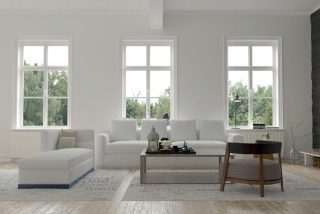 Modern living room with three large windows and white furniture.