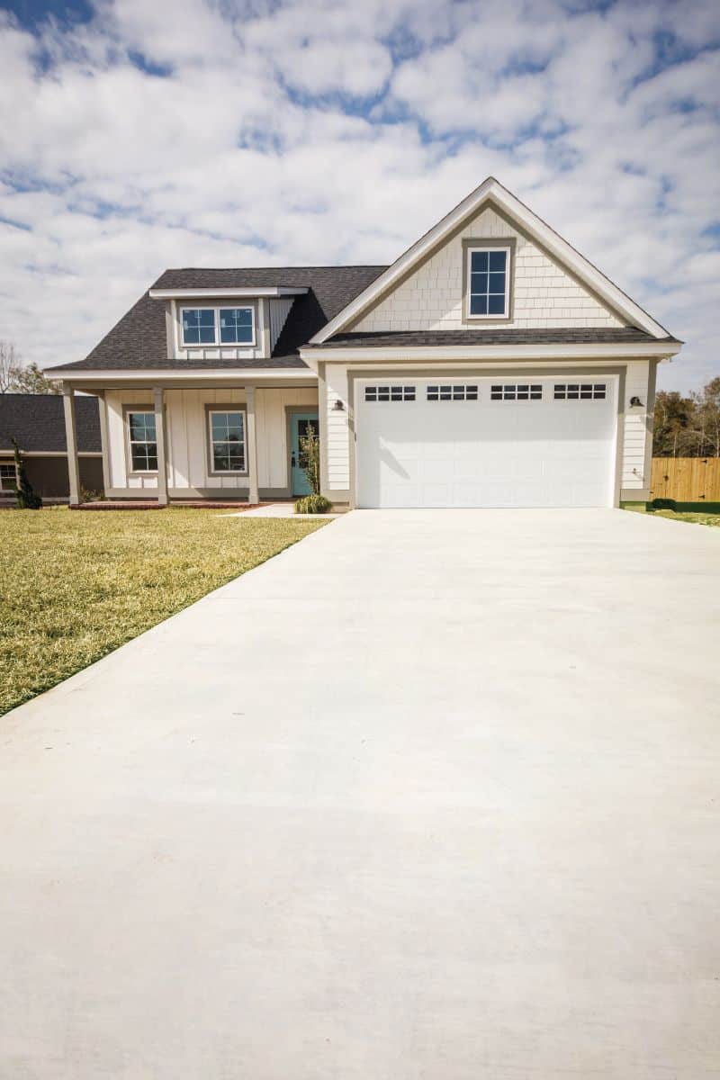 tan off white house with clean cement driveway