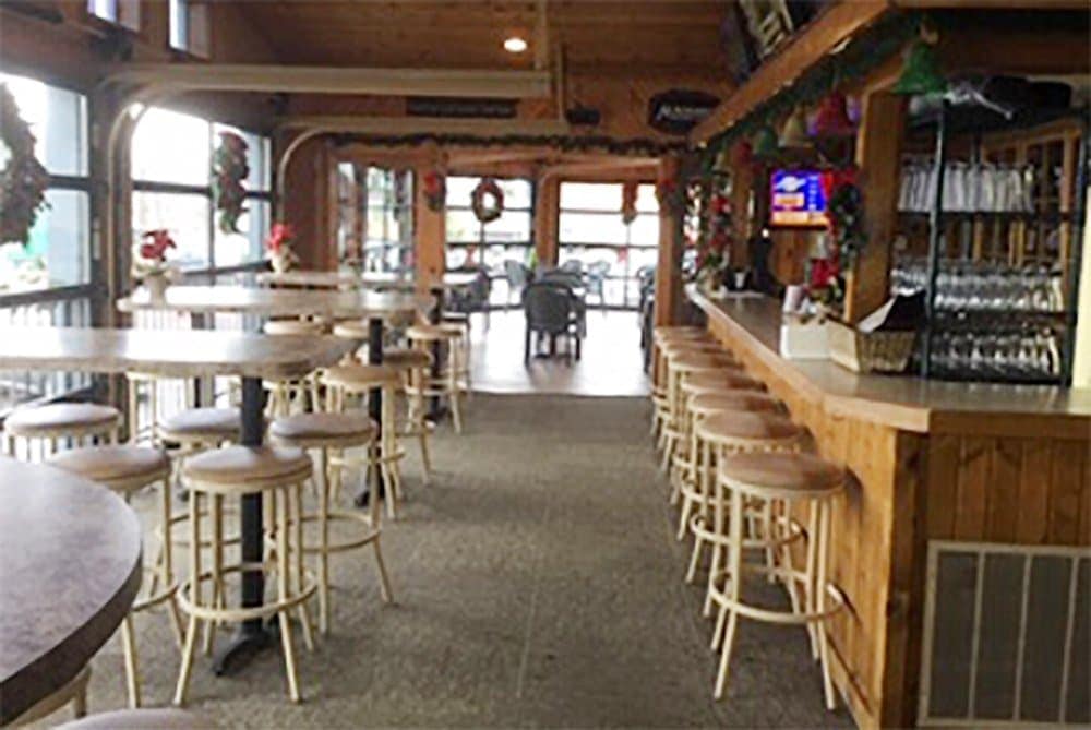 Cozy bar and dining area with high tables and bar stools at Leroy's Classic Bar & Grill.
