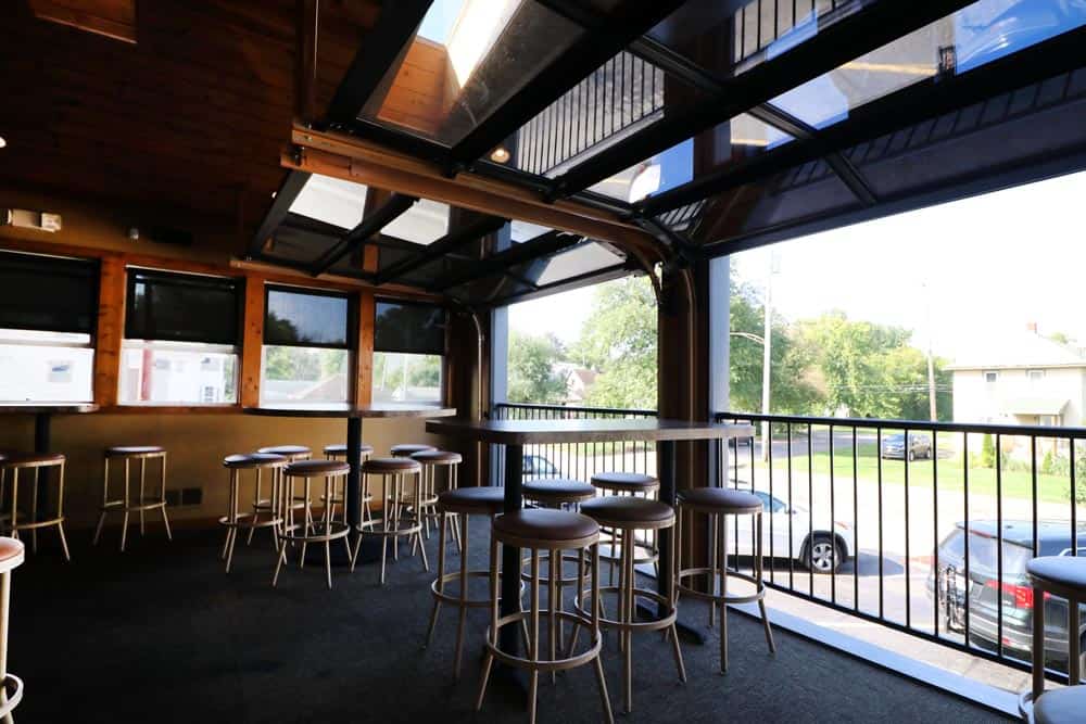 Bright interior with high tables and large windows at Leroy's Classic Bar & Grill.