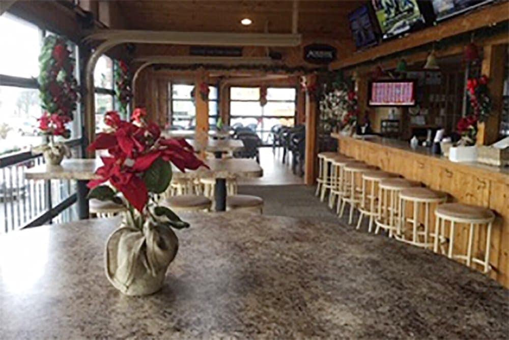 Cozy bar and grill interior with wooden decor and holiday decorations.