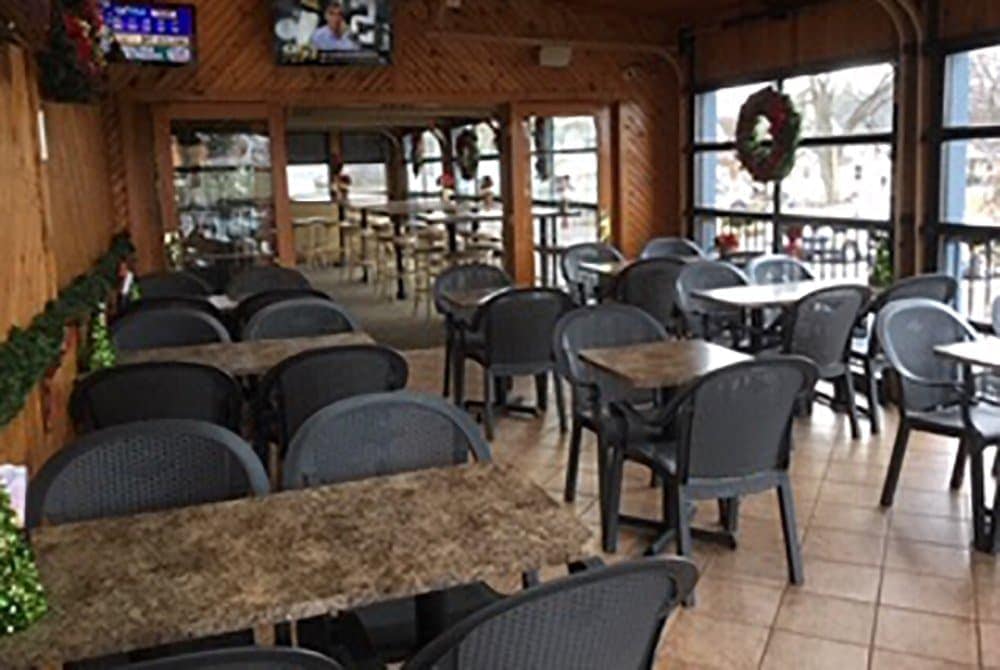 Indoor view of Leroy's Classic Bar & Grill with tables, chairs, and large windows.