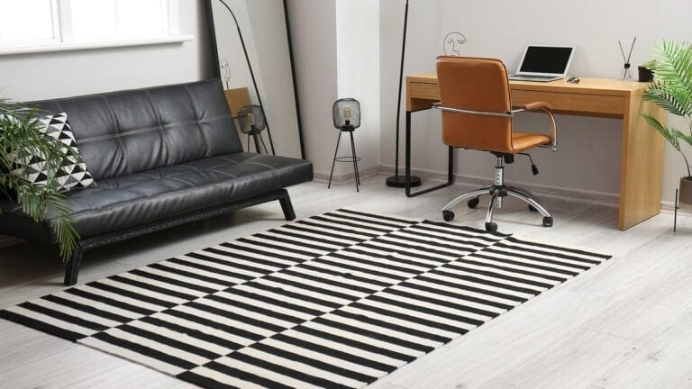 Šviesi svetainė su minkštu kilimu ant grindų ir sofa prie darbo vietos