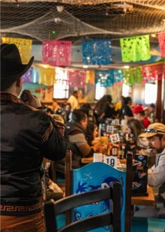 Colorful papel picado decorations in a lively Mexican restaurant.