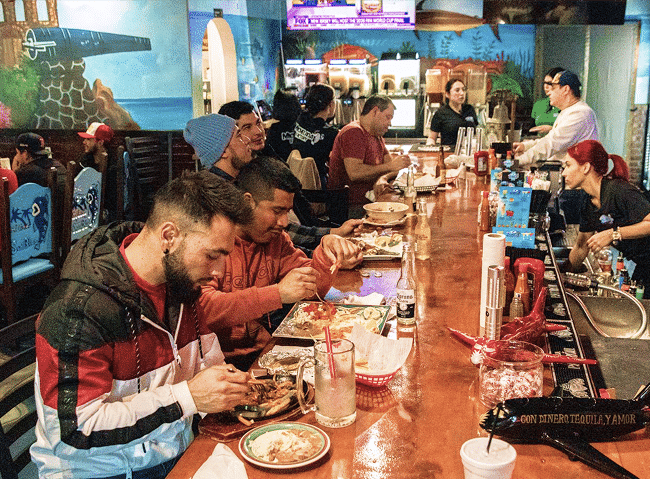 Smiling restaurant team and happy guests enjoying dinner service at Mi Lindo San Blas Detroit