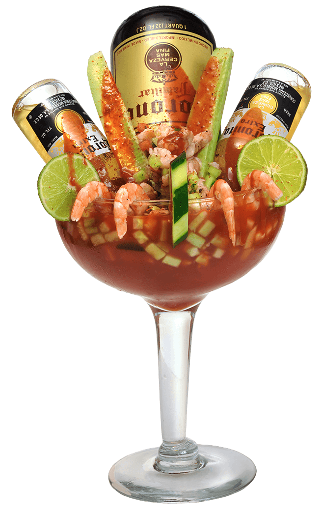 Seafood cocktail with shrimp, lime, and beer bottles in a glass.
