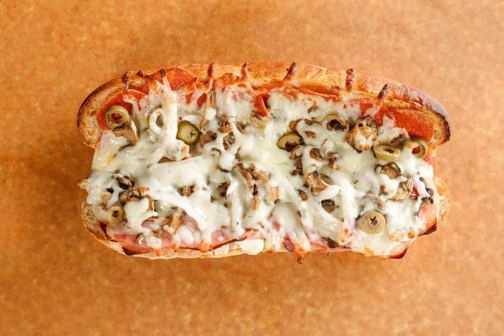 Close-up of a Sicilian pizza with cheese, pepperoni, and green peppers.