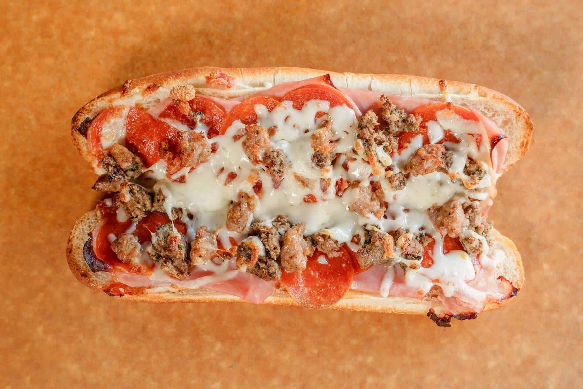 Close-up of Sicilian pizza with cheese, pepperoni, and sausage toppings.