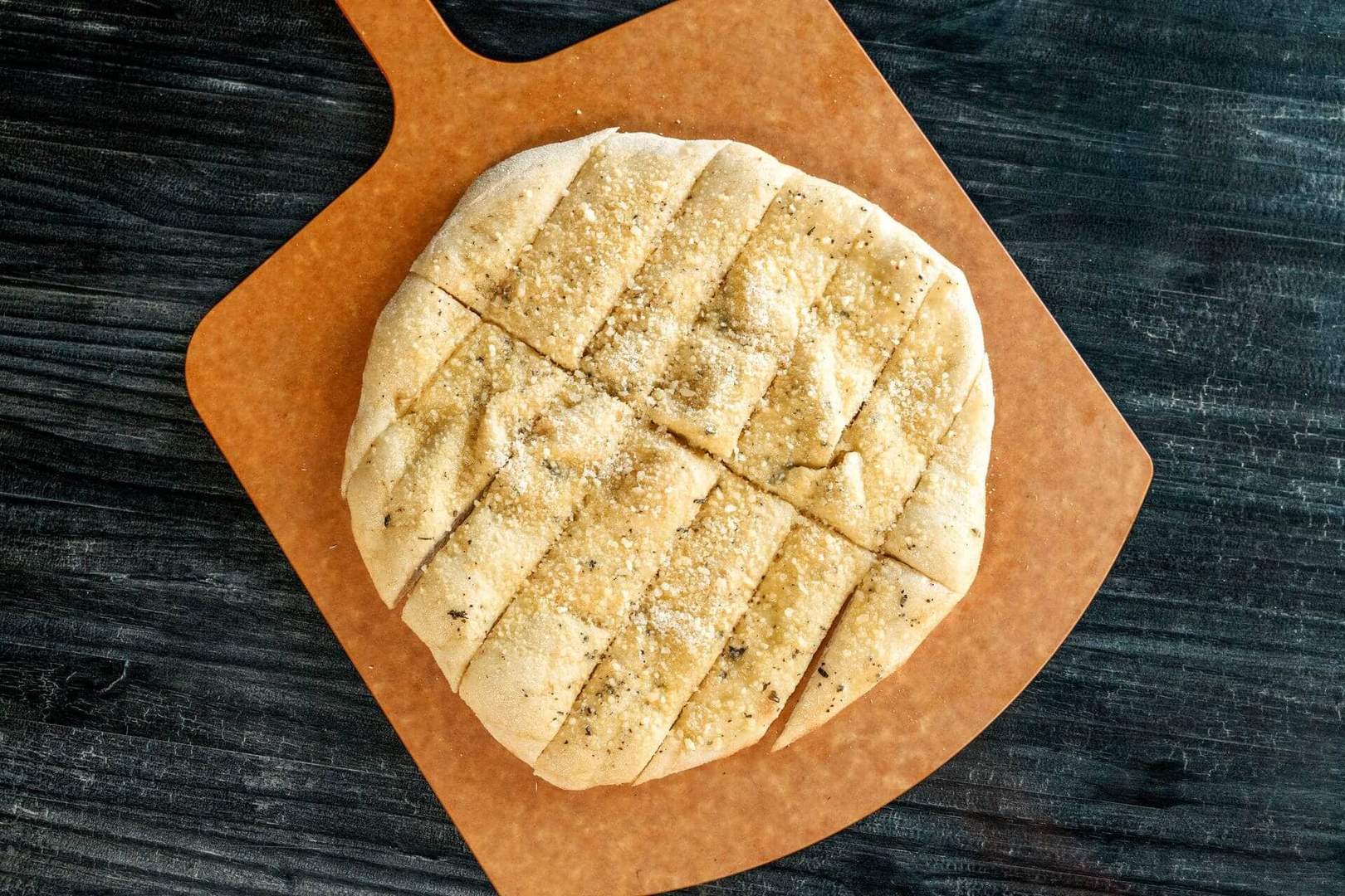 Close-up of sliced bread stix on a wooden board.