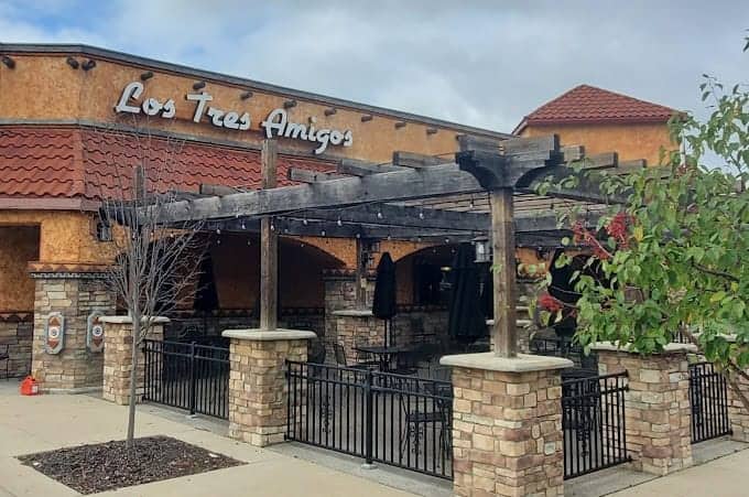 Exterior view of Los Tres Amigos restaurant with rustic brick and wood decor.