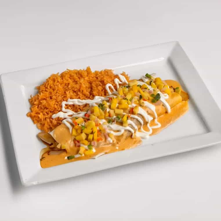 Fish fillet with mango salsa and rice on a white plate, served with colorful toppings.