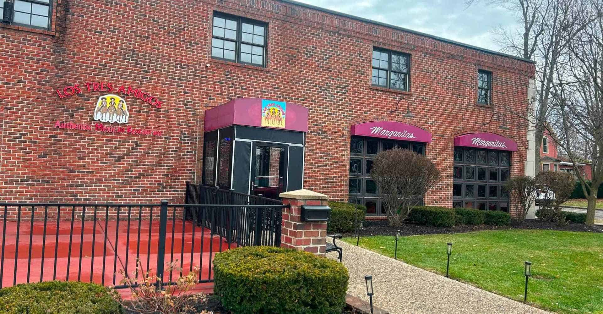 Exterior view of a brick building with "Mamasitas" signage and colorful storefronts.