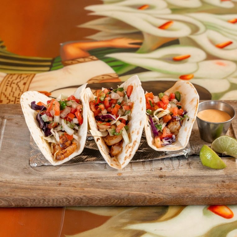 Delicious chicken tacos filled with fresh vegetables and served with lime and sauce.