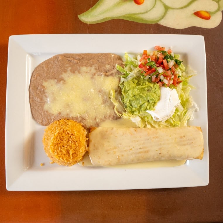 Delicious cheese enchiladas served with flavorful rice and fresh salad on a white plate. Perfect for.