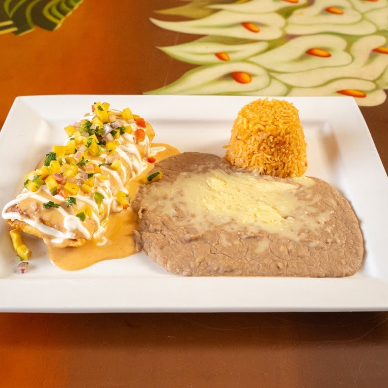 Juicy grilled steak served with rice and fresh salad on a white plate.