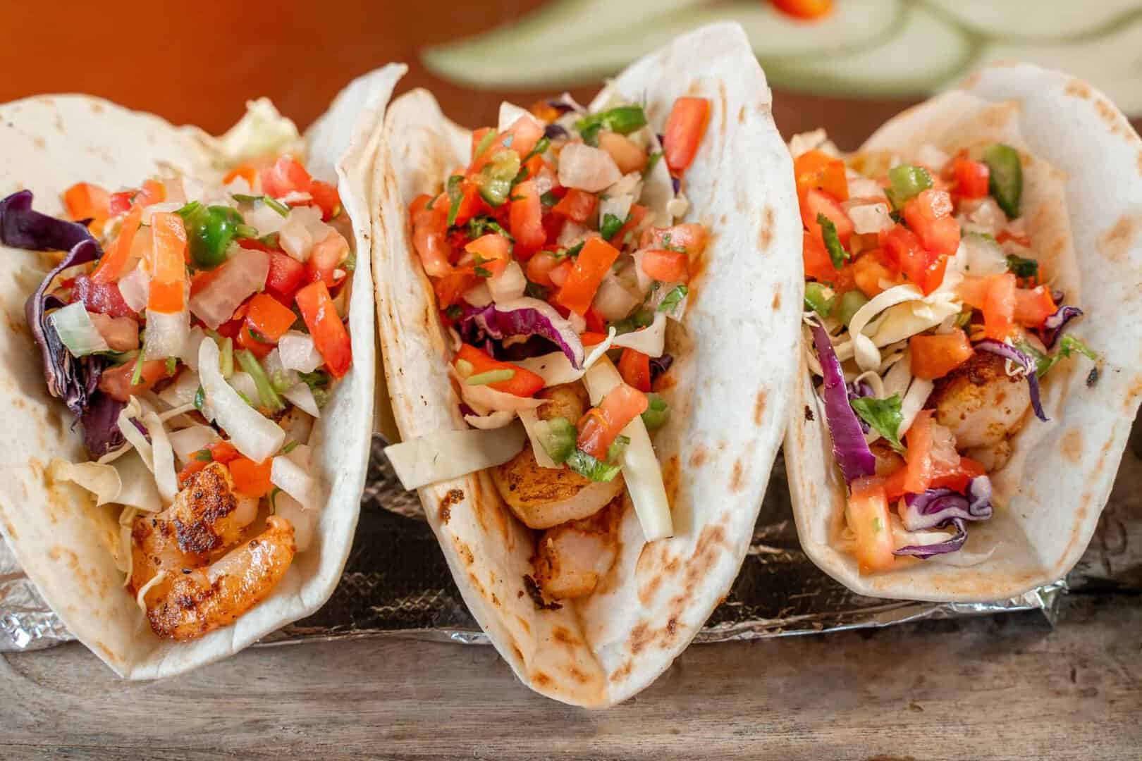 Chicken tacos with fresh vegetables and salsa in soft tortillas.