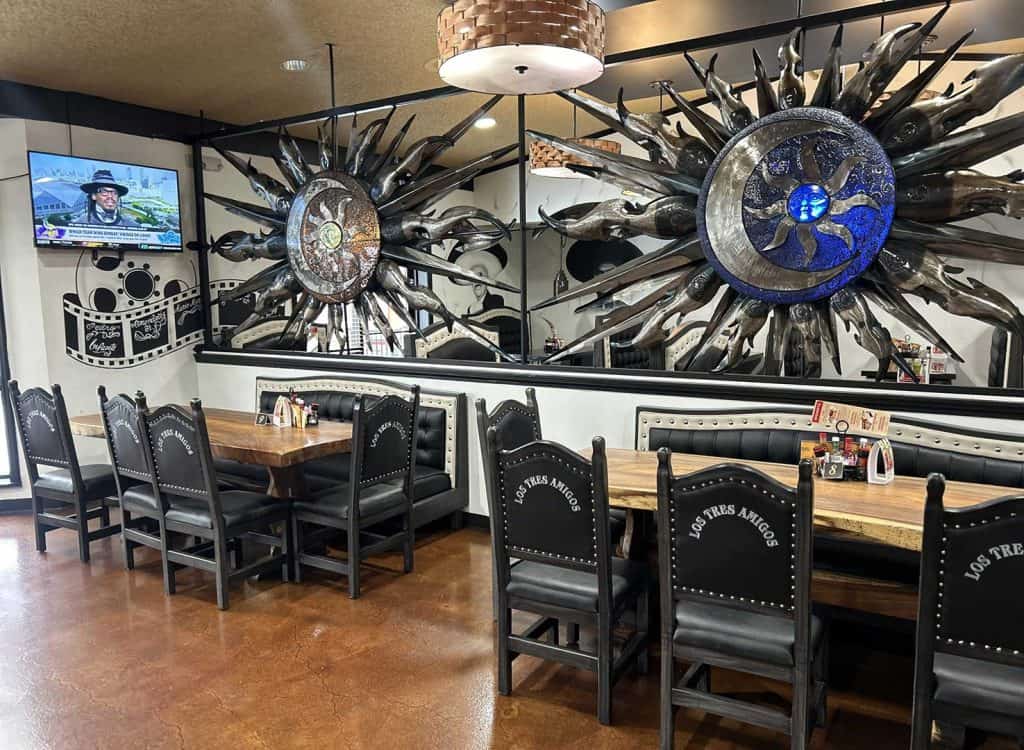 Sunburst wall decor with metallic rays and blue accents, enhancing the restaurant's modern industria.
