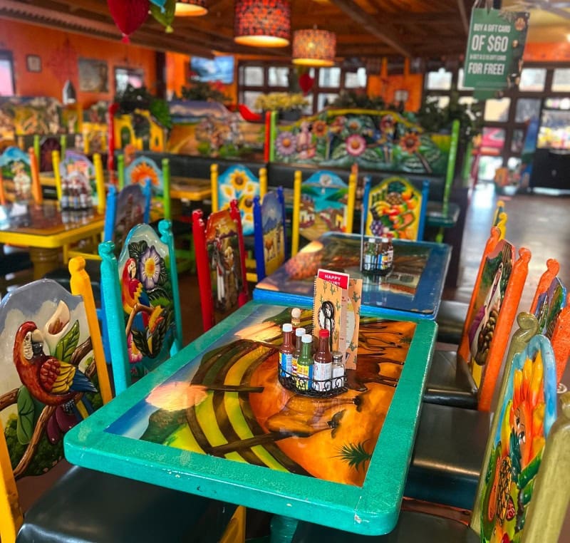 Vibrant Mexican restaurant with colorful decor, themed tables, and lively atmosphere.