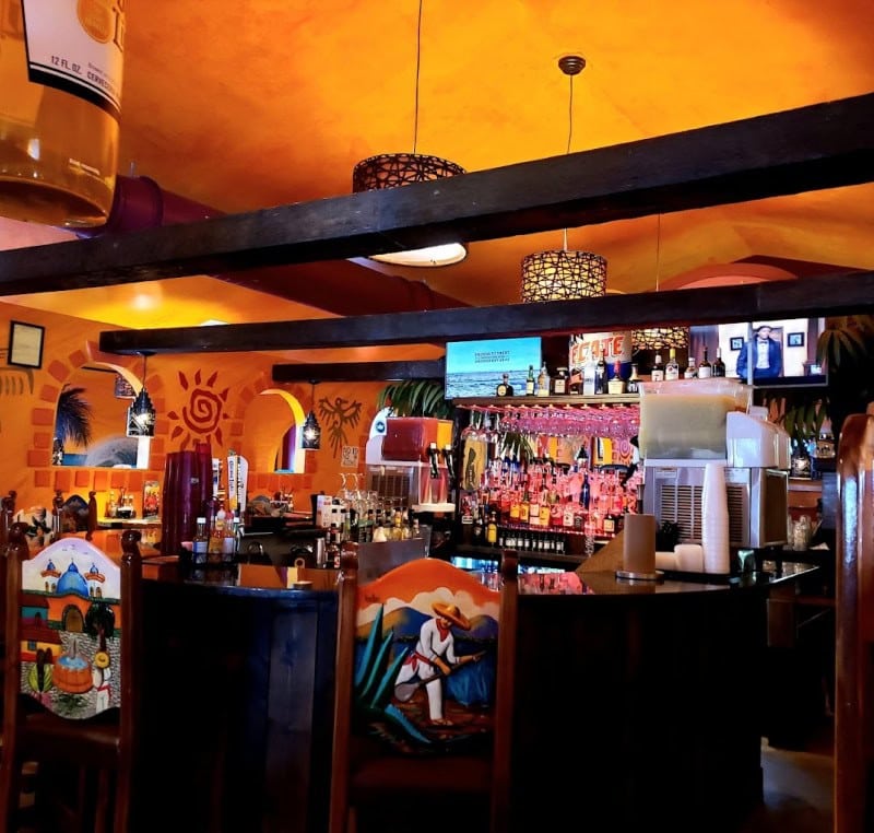 Vibrant tropical-themed bar with colorful decor and lively atmosphere.