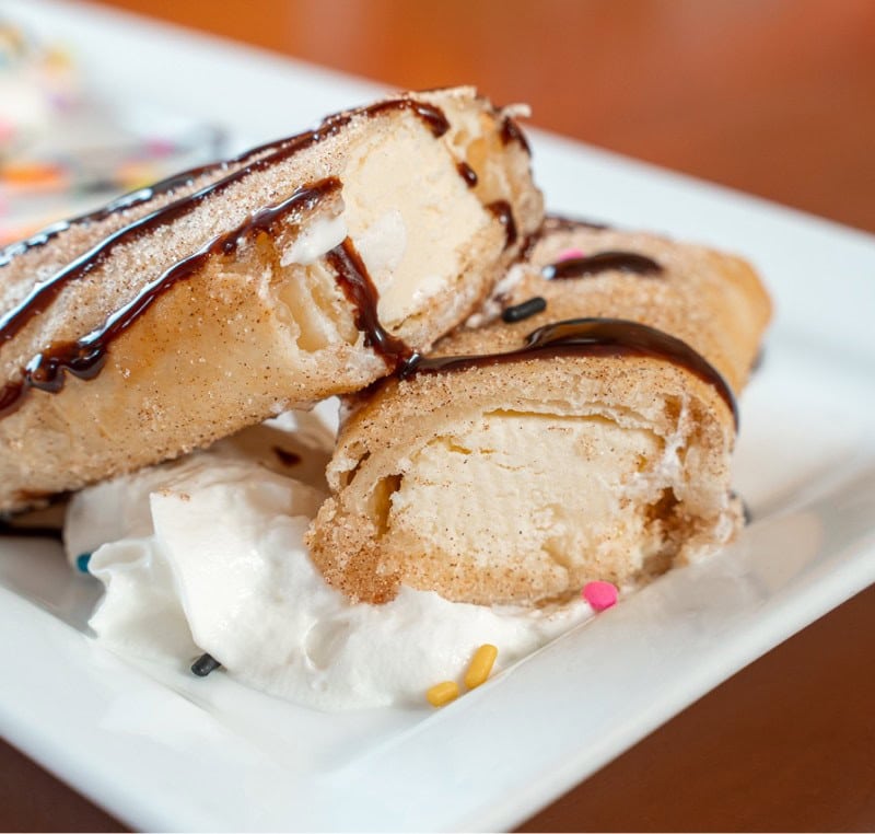 Delicious chocolate chip cookie sandwich filled with vanilla ice cream, topped with chocolate drizzl.