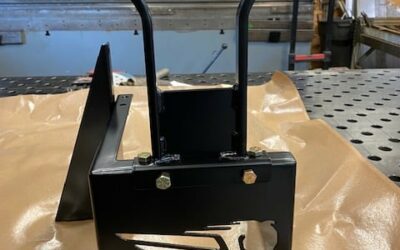Black metal bracket with handles and cutout design for industrial use.
