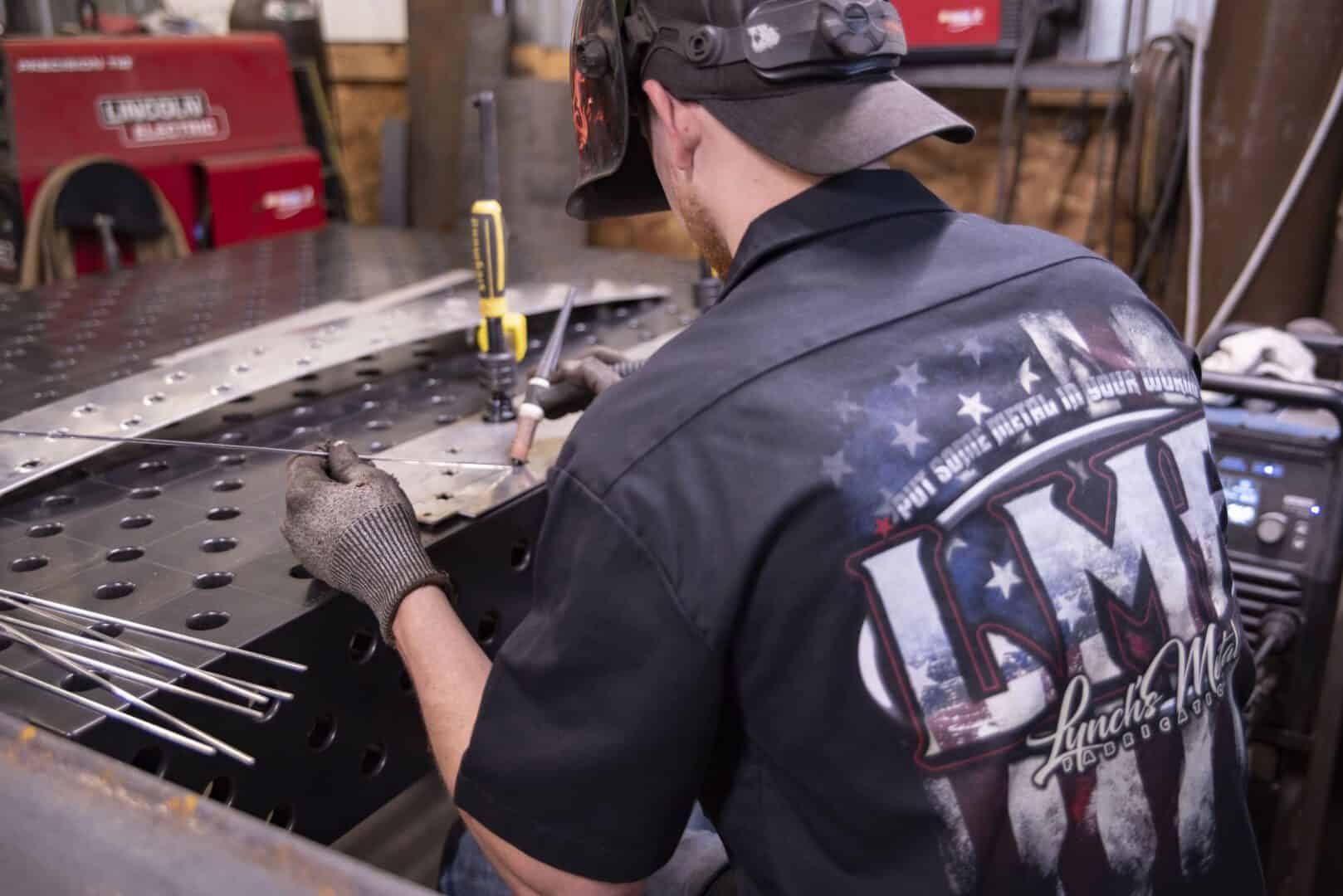 Worker welding metal in a workshop at Lynch's Metal Fab.
