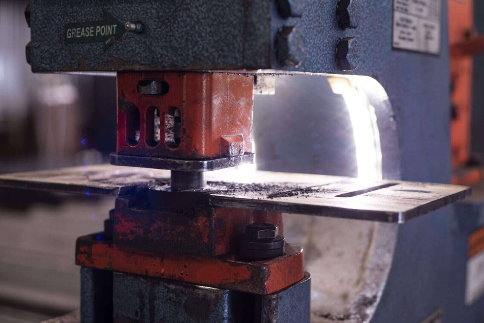 Close-up of a metal press machine used in fabrication processes.