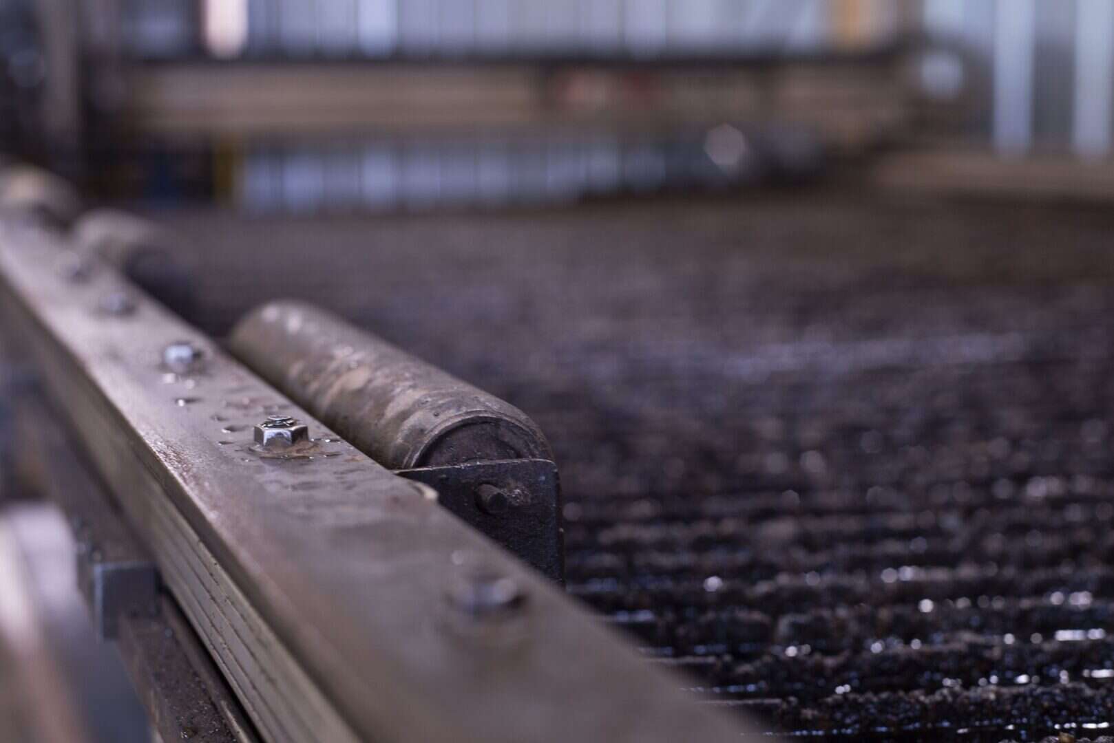 Close-up of metal roller on industrial conveyor at Lynch's Metal Fab.
