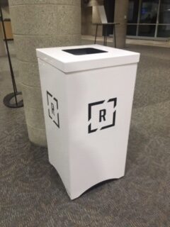 White custom metal trash bin with Lynch's Metal Fab logo in an indoor setting.