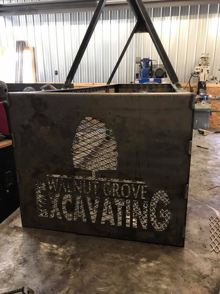 Metal sign with Walnut Grove and Caving cutout design.
