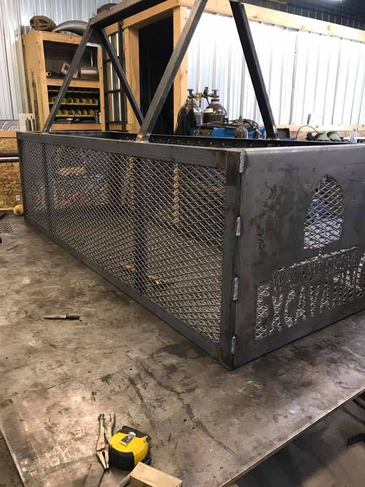 Industrial metal frame with mesh panels and support bars in workshop.