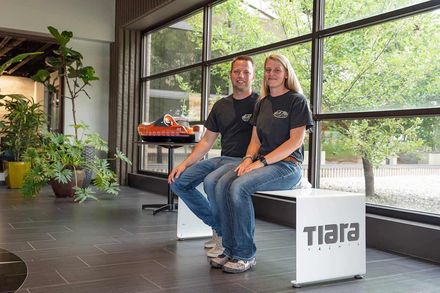 Two team members sitting on a bench inside Lynch's Metal Fab office.