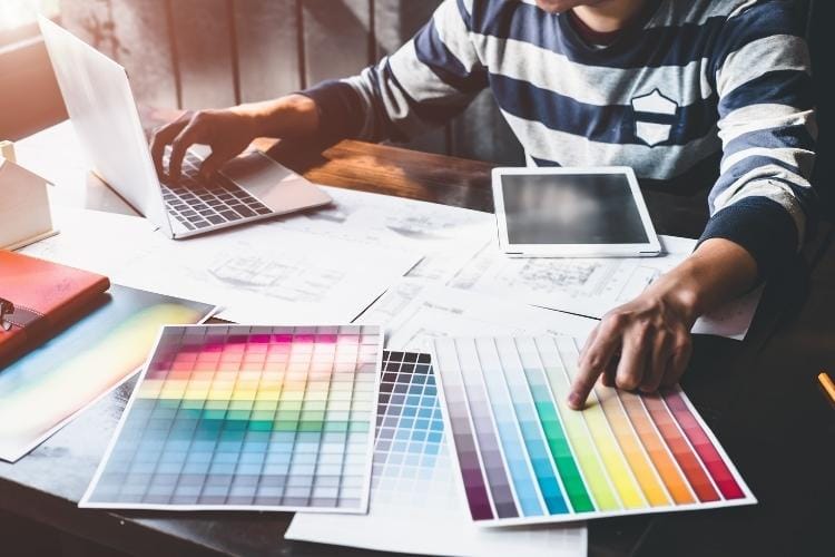 Designer entwirft Praxislogo am Laptop Designer entwirft Praxislogo am Laptop