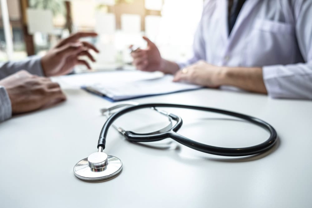 Vertragsarzt mit Kassenzulassung berät einen Patienten.