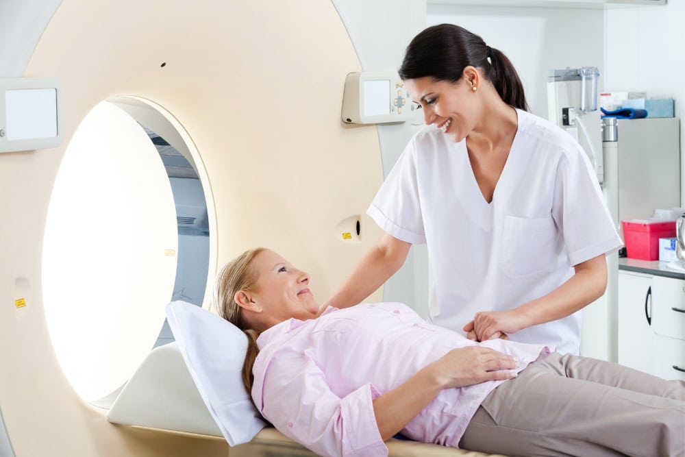 Eine Patientin mit Platzangst in einem CT-Gerät erhält Beistand. Eine Patientin mit Platzangst in einem CT-Gerät erhält Beistand.