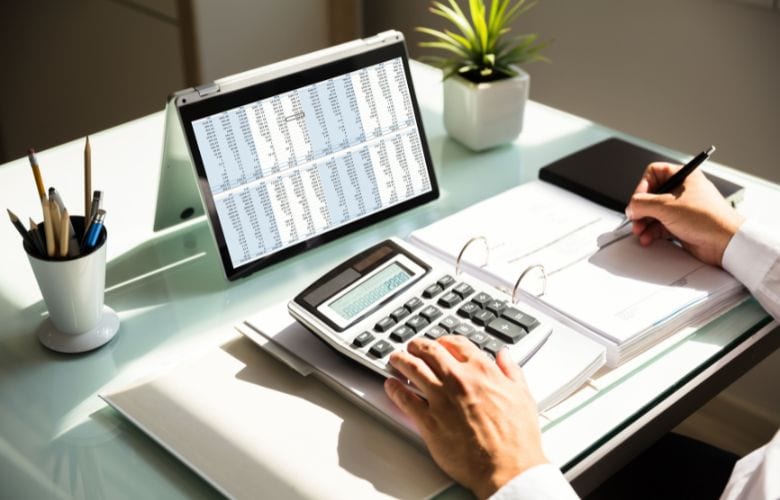 Abrechnungsdienstleister berechnet MVZ-Abrechnung mit Taschenrechner und Tablet