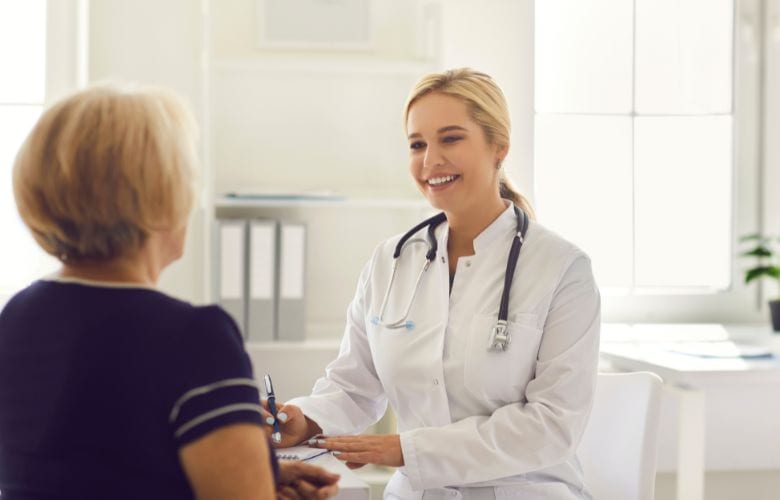 Ärztin im Gespräch mit Patientin in heller, moderner Praxisumgebung