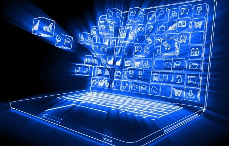 Ein leuchtender blauer Laptop mit schwebenden 3D-Icons für verschiedene Anwendungen vor einem dunklen Hintergrund.