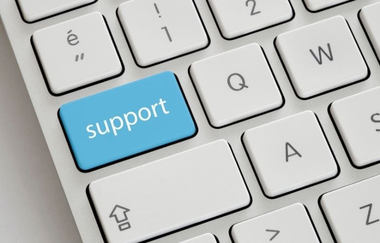Weiße Computertastatur mit einer blau hervorgehobenen Taste mit der Aufschrift "support" für IT-Support in der Arztpraxis.