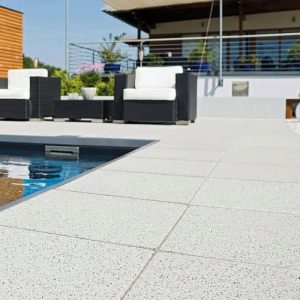 Outdoor poolside patio with modern seating and terrace railing for relaxation.